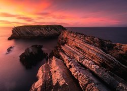 Zaróżowione niebo nad skalistym wybrzeżem