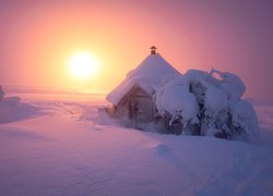 Zasypana śniegiem drewniana chata