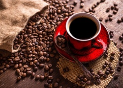 Ziarna kawy rozsypane obok filiżanki z kawą