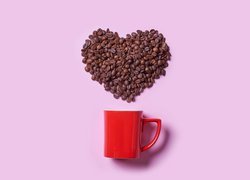 Ziarna kawy w kształcie serca nad kubkiem