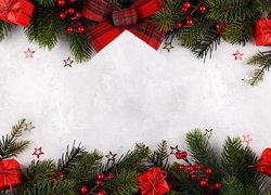 Zielone gałązki ozdobione kokardką i małymi prezentami