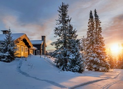 Zimowy krajobraz ze wschodzącym słońcem i domami