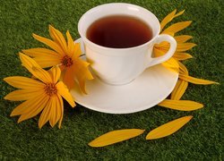 Żółte kwiaty przy filiżance herbaty
