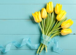 Żółte tulipany przewiązane wstążką w kropki