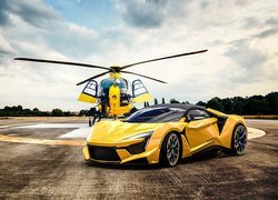 Żółty Fenyr SuperSport obok helikoptera