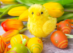 Żółty kurczaczek pośród tulipanów i pisanek