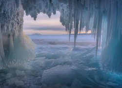 Zwisające sople w lodowej grocie nad morzem